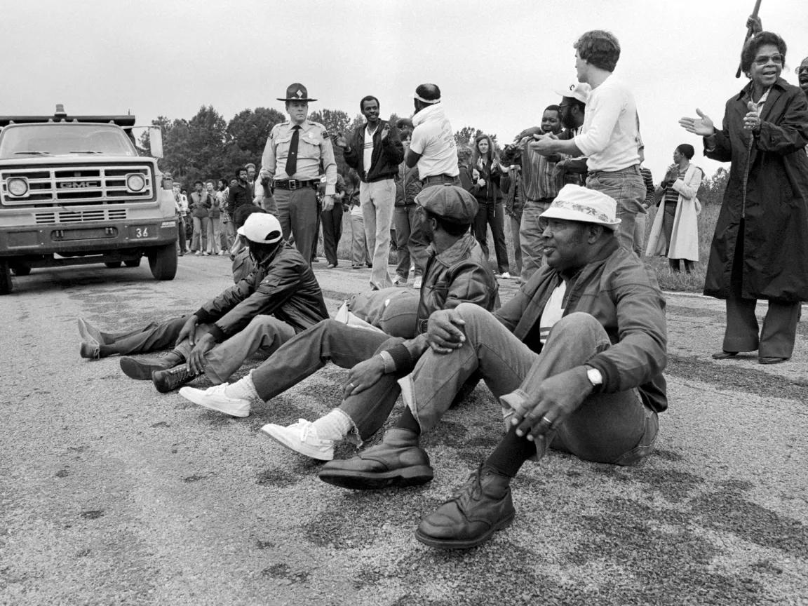 Protesters sitting in the middle of the road to block a truck’s path on its way to a landfill in Afton, North Carolina