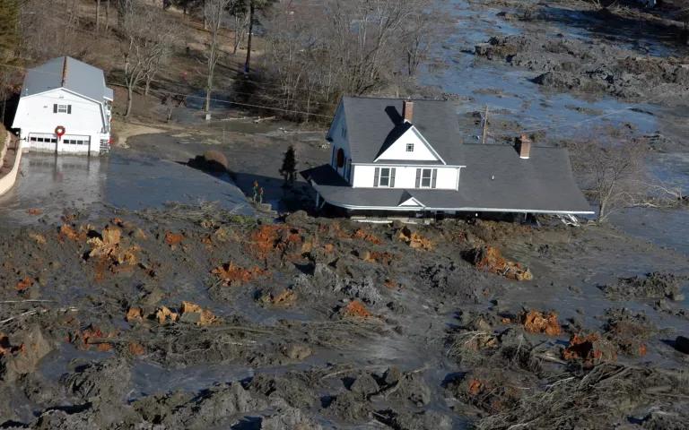 The ground level of a two-storey home is almost completely submerged in mud