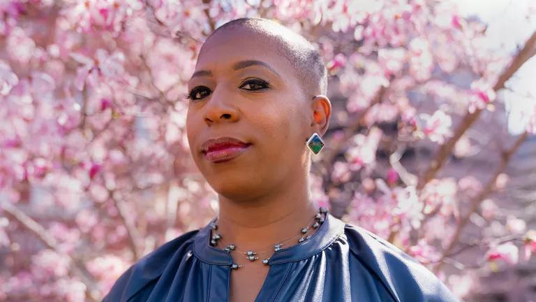 Dr. Ticora V. Jones with a cherry blossom tree blooming behind her
