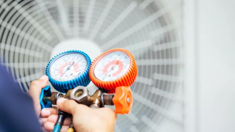 HVAC contractor checking the refrigerant pressure of an AC unit