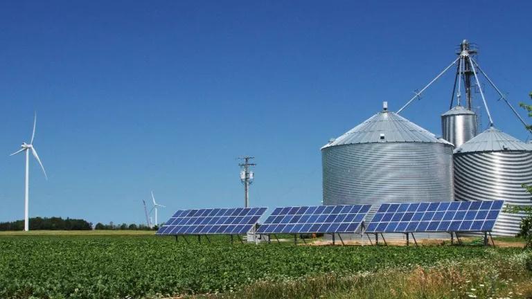 Solar panels, wind turbines and grain storage bins on a farm in Palms, Michigan.