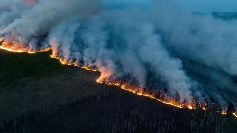 An aerial view of wildfire encroaching on Canadian forests