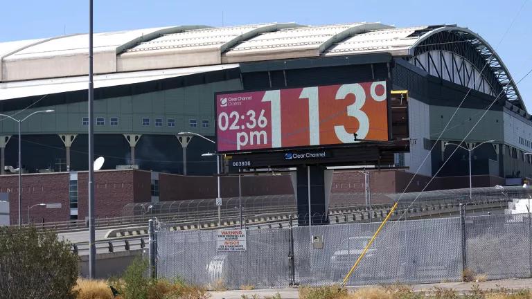 A digital billboard near a baseball stadium reads, "2:36pm, 113 degrees Fahrenheit."