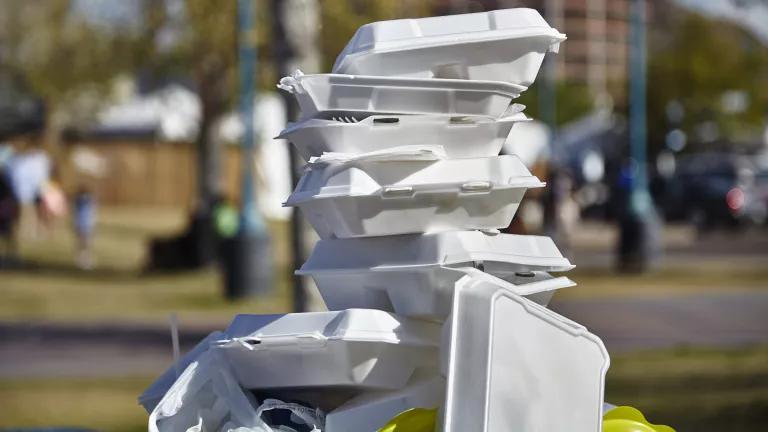 A pile of polystyrene food containers on a trash can.
