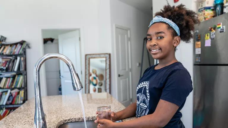 Zylaa Dwyer, 10, filling a glass of water in the kitchen sink at her home in Washington, DC.