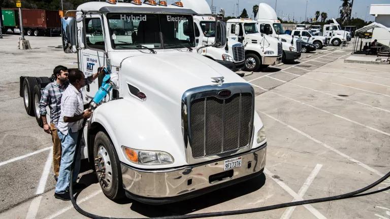 An electric hybrid semi truck being plugged in to recharge at the Port of Long Beach