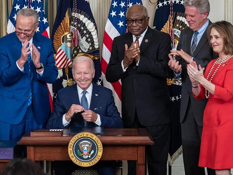 The signing of the Inflation Reduction Act, with Biden sitting in the middle, surrounded by (left to right): Senator Joe Manchin, Senate Majority Leader Charles Schumer, House Majority Whip James Clyburn, Representative Frank Pallone, and Representative Kathy Catsor