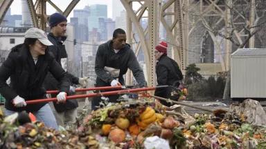 People help to churn the compost—a giant pile of organic residential waste—in Big Reuse’s space under the 59th Street Bridge