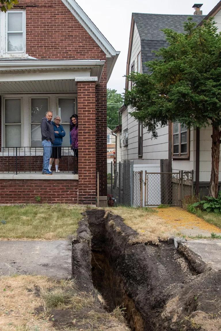 NRDC Midwest Outreach Manager Gina Ramirez and her parents looking at a ditch dug during replacement of a lead service line outside their home in Chicago