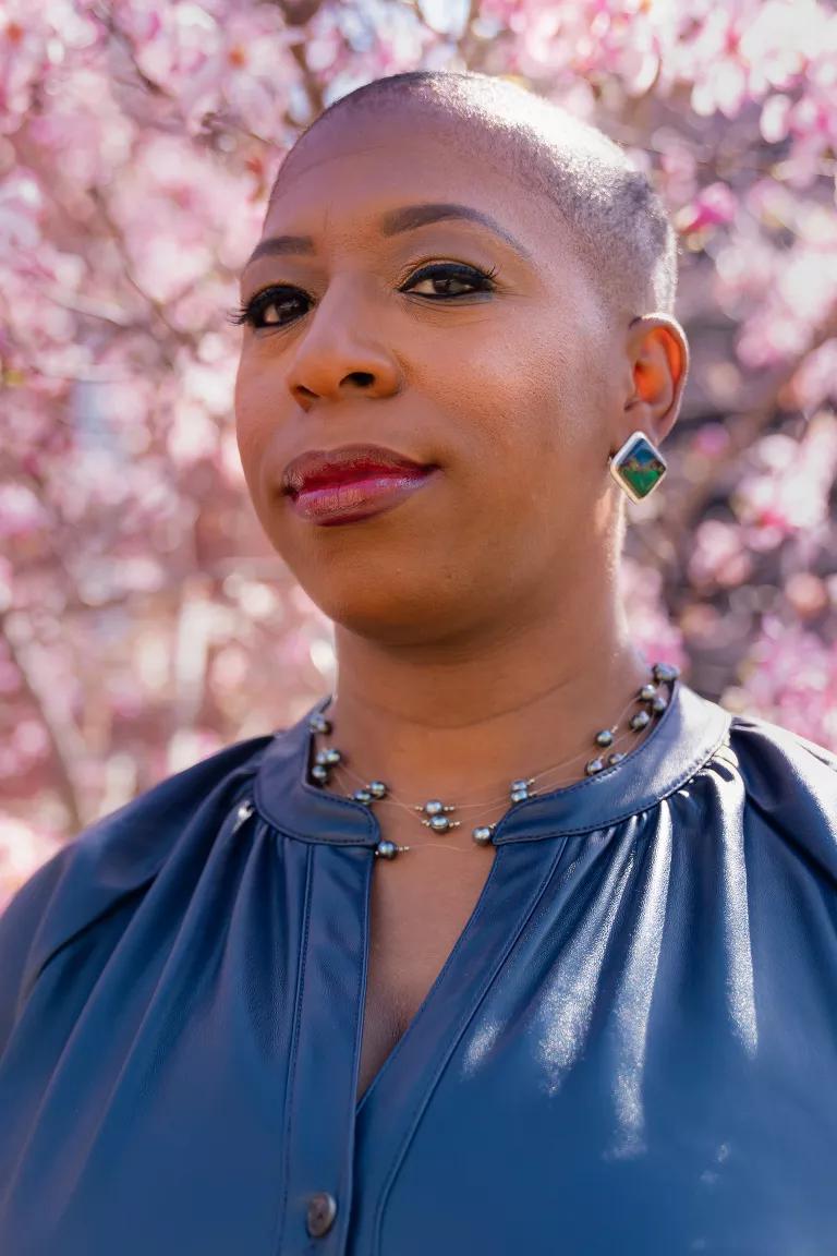 Dr. Ticora V. Jones with a cherry blossom tree blooming behind her