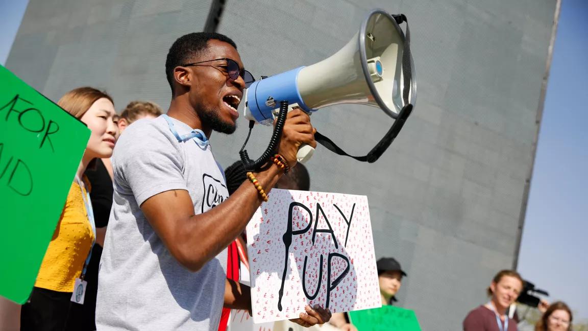 An activist speaking through a megaphone during a protest at the 2022 United Nations Climate Change Conference (COP27) in Sharm El Sheikh, Egypt, on November 14, 2022