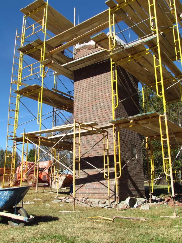 A multi-story brick tower with scaffolding surrounding it