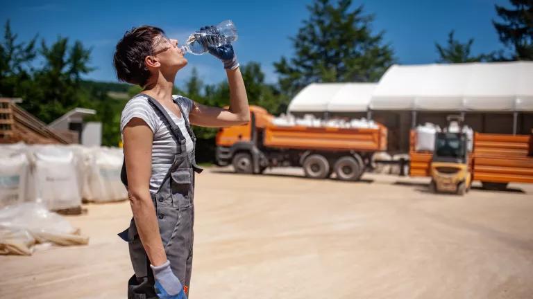 A worker drinking bottled water at an ore processing plant.