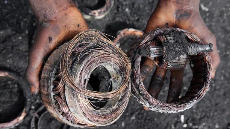 A person holds partially-burned coils of wire