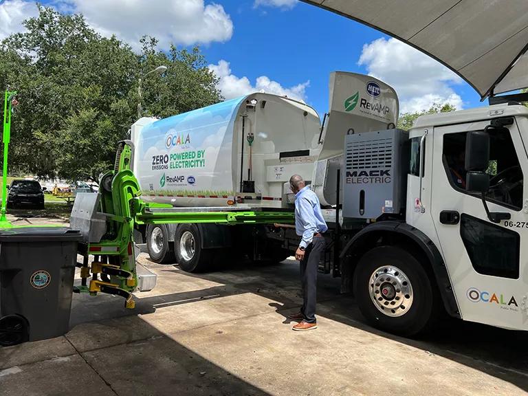 A man tending to an electric garbage truck in Florida