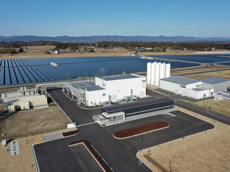 A wide-angle aerial view of a green hydrogen facility powered by solar panels in Fukushima, Japan