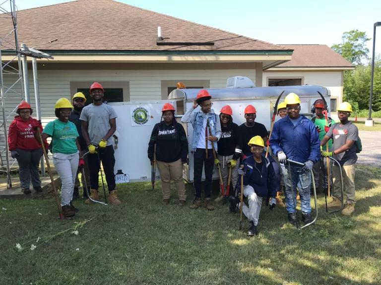 A group of people in hard hats posing in front of a house