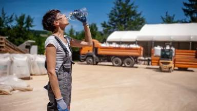 A worker drinking bottled water at an ore processing plant.