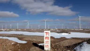 "Optical Cables Below" reads a sign outside a wind farm in Yumen, Gansu province
