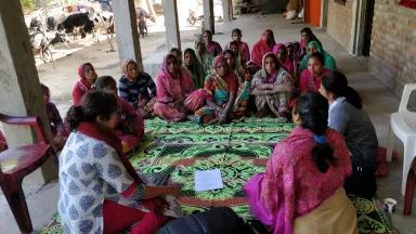 women in India sit in a circle having a discussion about clean energy solutions