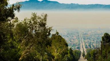 Thick smog hangs over city streets in a valley