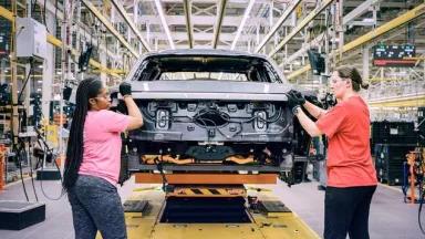 Shemika Winston (left) working on the 2022 Ford F-150 Lightning Pro electric pickup truck production line at the Electric Vehicle Center on the grounds of the Ford River Rouge complex in Dearborn, Michigan