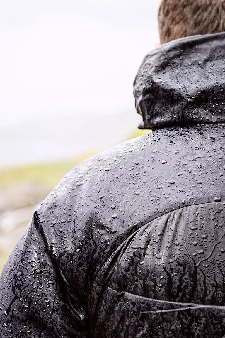 The back of a person wearing a black waterproof jacket 